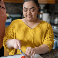 Disabled woman chopping vegetables in kitchen