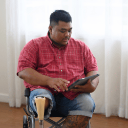Disabled man in wheelchair looking at iPad