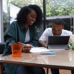 Disabled man and support worker looking at laptop at home together