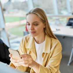 Woman in Yellow blazer using mobile phone