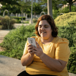Woman wearing Yellow tshirt sitting outside using mobile phone
