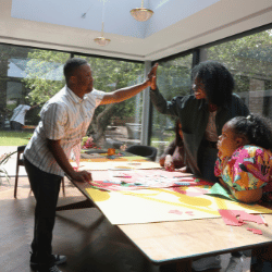 Disabled man with down syndrome high fiving support worker