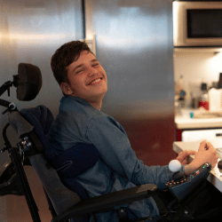 Disabled boy in wheelchair smiling at camera