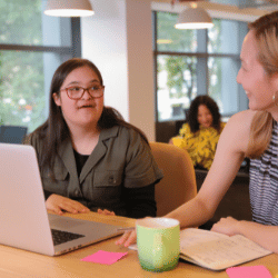 Disabled woman with down syndrome smiling with support worker