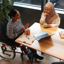 Disabled woman in wheelchair speaking with support worker