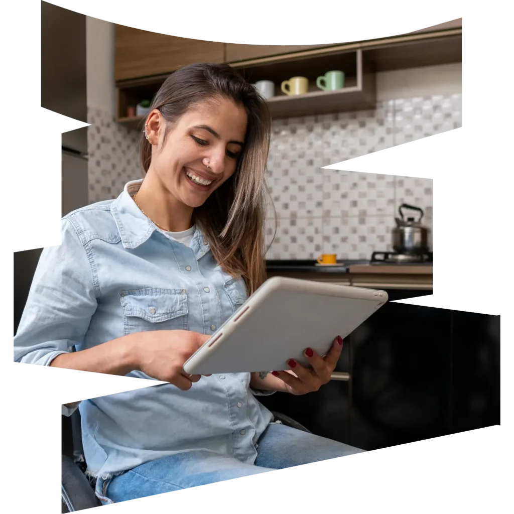 Disabled woman in wheelchair in kitchen using iPad
