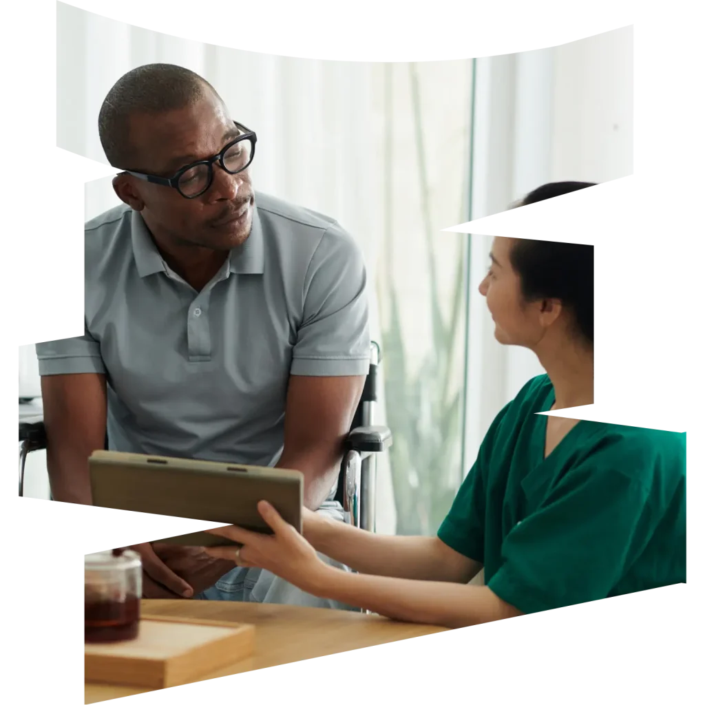 Disabled man in wheelchair talking with nurse at home